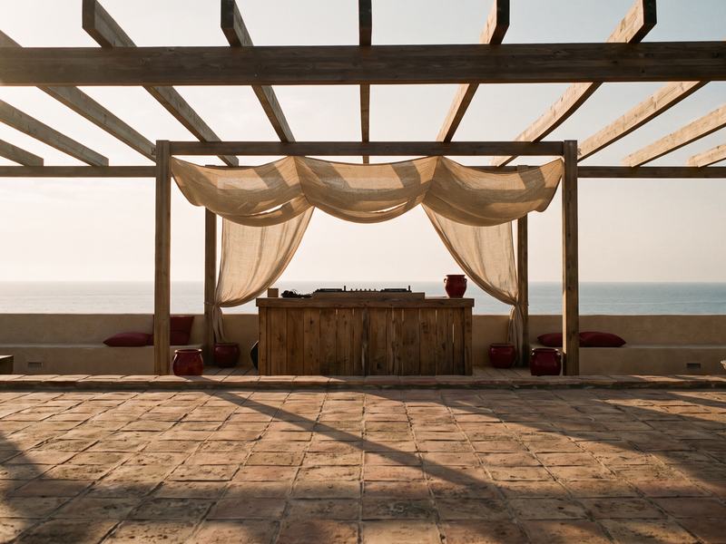 Prague-style rooftops above the clouds with an empty DJ booth, AI dreamscape